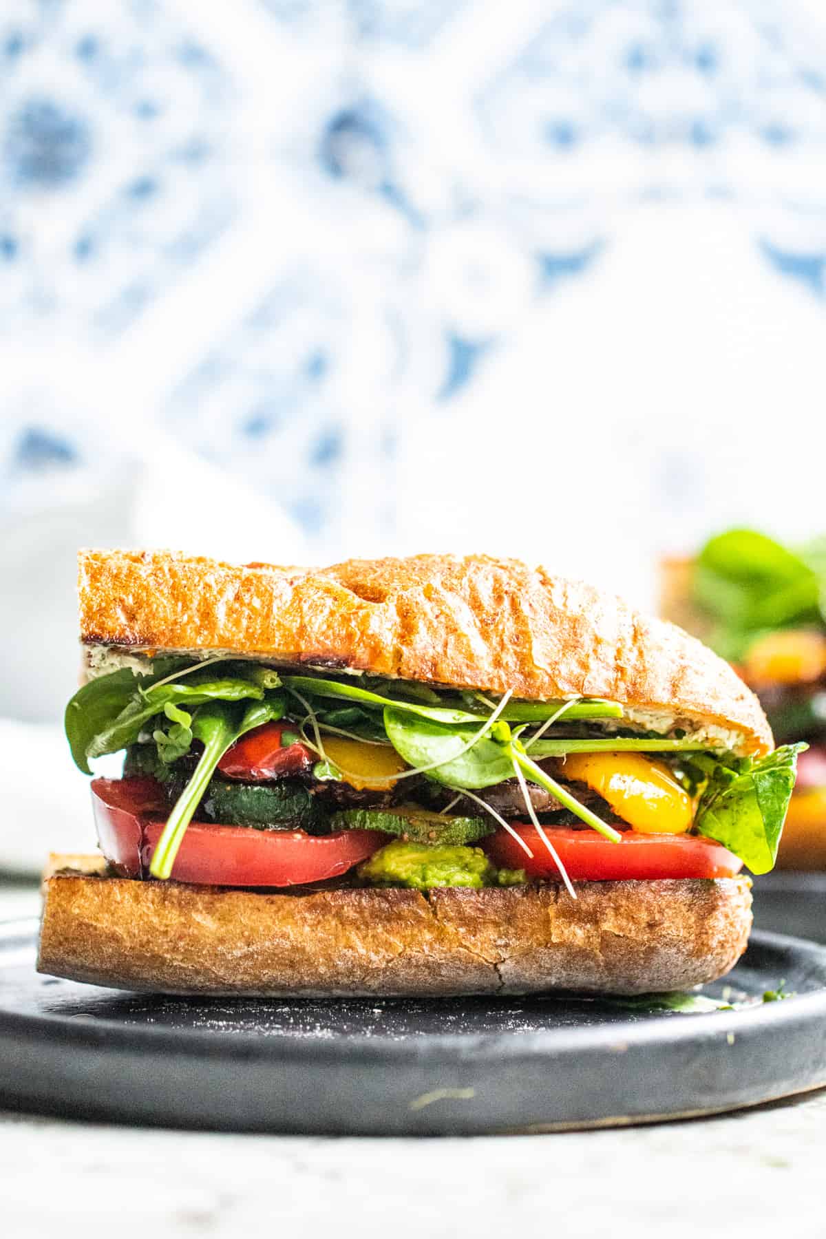 Strait on shot of veggie sandwich on a dark gray black with white and bluw background.